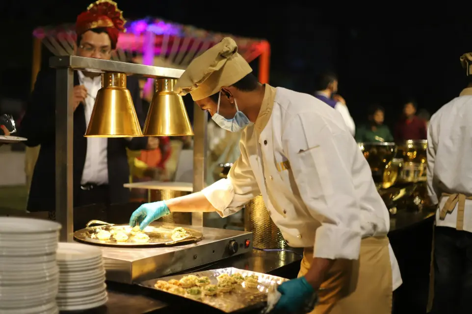 homme en uniforme de chef blanc en train de cuisiner