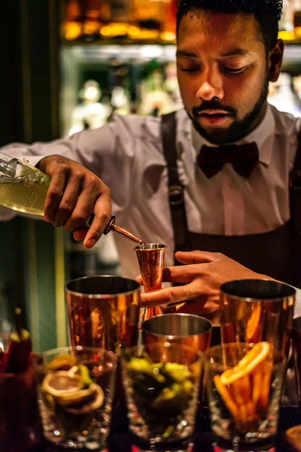 personne versant du liquide dans un récipient à partir d'une bouteille